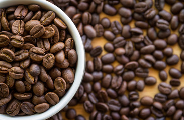 Close up of white coffee cup full of coffee beans background with copy space