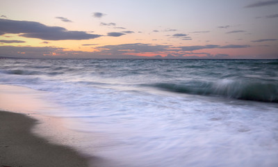 Fototapeta na wymiar Seaside in sunset, sandy beach with waves in Platamon, Platamonas, Olympic region Greece