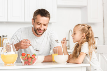 father and daughter having breakfast at kitchen