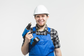Happy caucasian male builder with screwdriver on white background, wearing white helmet.