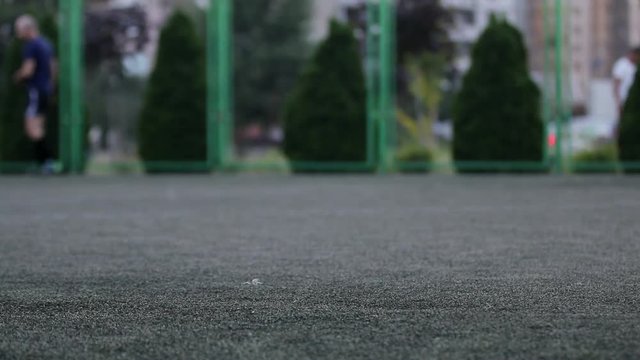 Close up aut focus of men`s feet playing and running through football  field in the city park. Shallow depth of the field, toned video, 50fps.