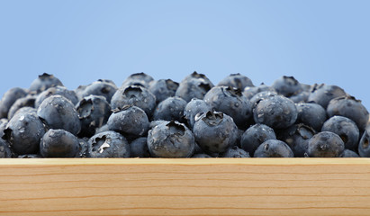 Heap of fresh washed blueberries in wooden box
