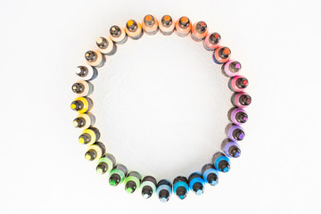 Circle of colorful paints in small plastic battles