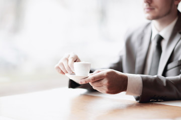 close up.businessman holding a Cup of coffee sitting at his Desk