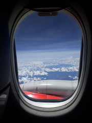 Fototapeta premium Looking out the window of airplane, Sky with white clouds viewed from inside an airplane windows
