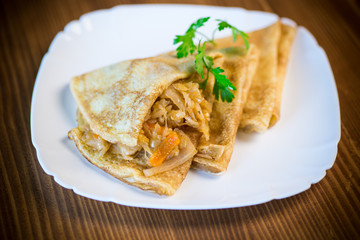 thin fried pancakes stuffed with stewed cabbage in a plate