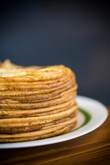 big high stack of thin pancakes in a plate