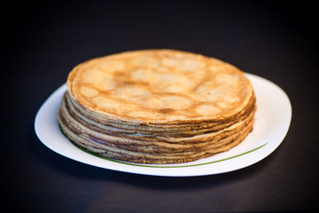 big high stack of thin pancakes in a plate
