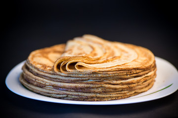 big high stack of thin pancakes in a plate