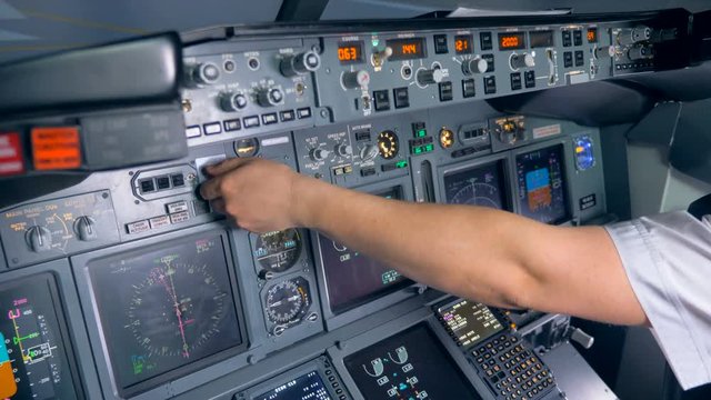 Indicators of an aircraft console are getting switched on and off by a pilot
