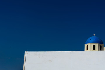 Church with white facade and blue cupola at Oia, Santorini, Greece