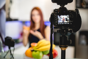 Young woman blogging and prepare fruit mix
