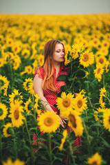 Obraz na płótnie Canvas Beautiful girl in a huge yellow field of sunflowers.