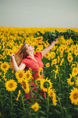 Fototapeta premium Beautiful girl in a huge yellow field of sunflowers.