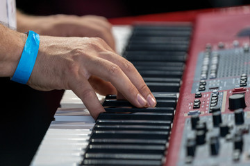 Obraz premium Hands of a musician on a red keyboard