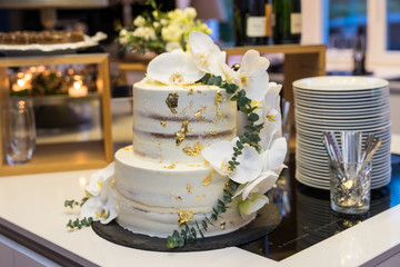 Wedding cake with cream and flower decoration and gold leaf