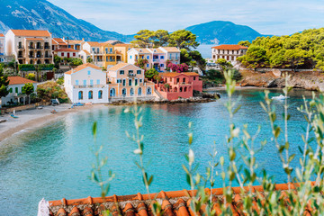 Assos village in Kefalonia, Greece. Turquiose bay, quite beach and colored traditional houses. Red roofs in front