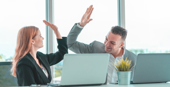 Male boss Hi five to female worker for success