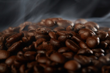 grains of coffee with smoke on a dark background