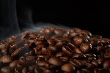 grains of coffee with smoke on a dark background