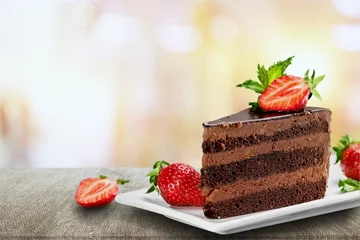 Poster Slice of delicious chocolate cake on desk © BillionPhotos.com