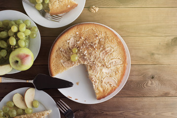 Freshly baked apple pie rustic, dark wood background. Autumn fruits: grapes, apples, nuts. Still life dessert homemade food, top view.