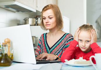 woman working from home, little daughter asking for attention