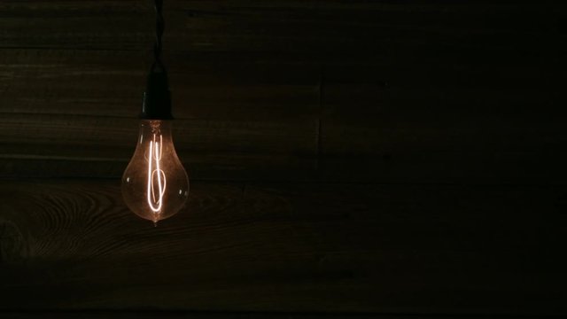 EDISON BULB SLOWLY ILLUMINATES, WITH NEGATIVE SPACE