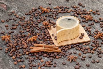 Wooden cup of coffee and coffee beans