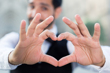 Passionate man making heart with finger
