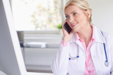 Female doctor consulting with her patient on mobile phone