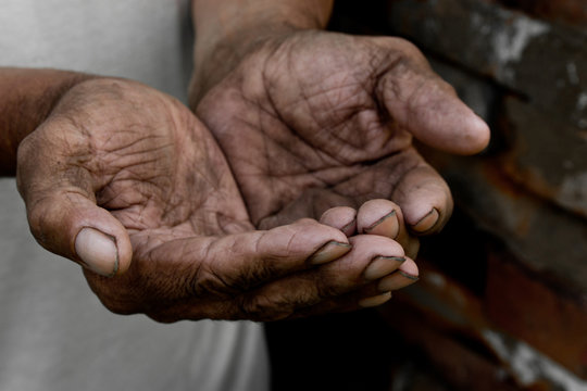 The poor old man's hands beg you for help. The concept of hunger or poverty. Selective focus. Poverty in retirement. Alms