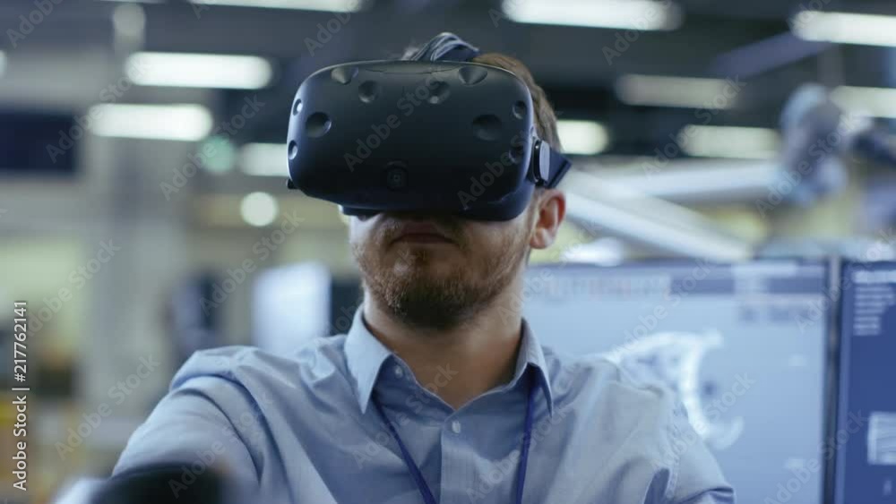 Poster portrait shot of the industrial engineer wearing virtual reality headset and using controllers, read