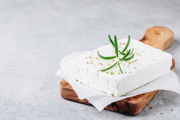 Homemade greek cheese feta with rosemary and herbs on wooden board - obrazy, fototapety, plakaty
