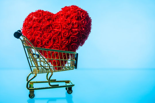 Heart in a shopping trolley. Gold shopping cart. I like shopping. Lovers go shopping. Red heart.