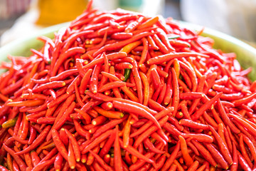 Piles of fresh red chilli peppers for sale in the market.
