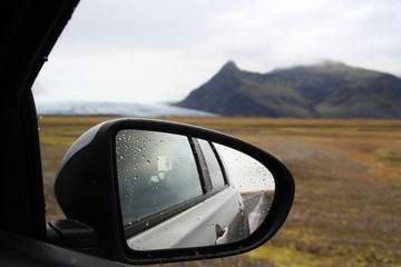 Espejo retrovisor y paisaje un día de lluvia en islandia.