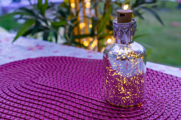 Obraz na płótnie Canvas Table decoration with illuminated bottle