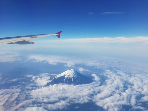 Top view of fuji mountain and wing of the air plane from window airplane with an Aerial view background, Yamanashi, Japan - Powered by Adobe