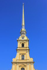 Fototapeta na wymiar Peter and Paul Cathedral at Peter and Paul Fortress in Saint Petersburg, Russia. Bell Tower of Russian Orthodox Church, Building Architecture Details. Church Tower View on Clear Blue Sky Background.
