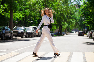 Young happy brunette woman in white business suit