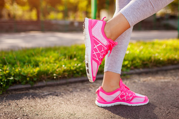 Young woman athlete warming up before running on sportsground in summer. Active lifestyle