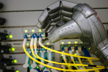 The robot's hand connects the optical wires to the main router. A mechanical hand switches wires in...