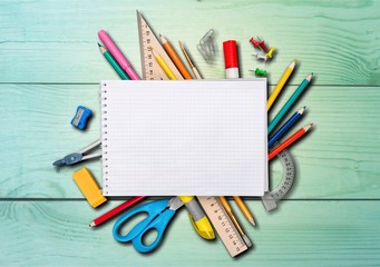 Colorful school supplies on wooden table background
