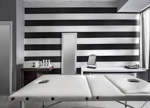 View of an Interior of a modern clean massage room with black and white luxury decor.