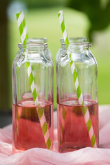 Flaschen mit rotem Getränk und Strohhalm