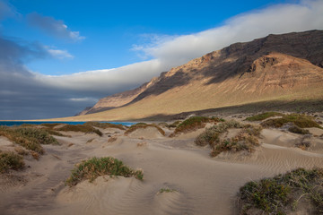 Sand dunes and ocean landscape on sunset