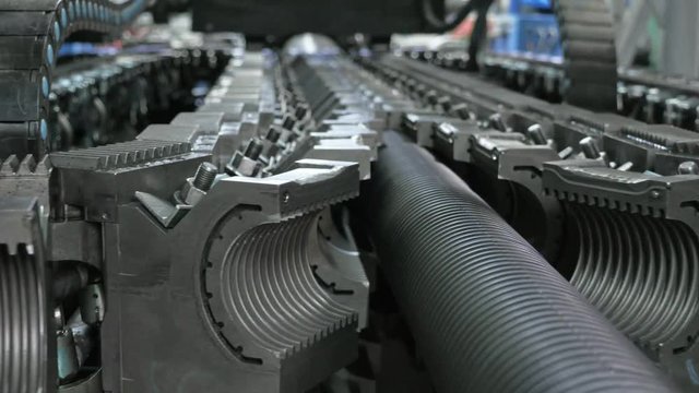 Manufacture of plastic water pipes. Manufacturing of tubes to the factory. The process of making plastic pipes on the machine tool with the use of water and air pressure. Special corrugated forms of