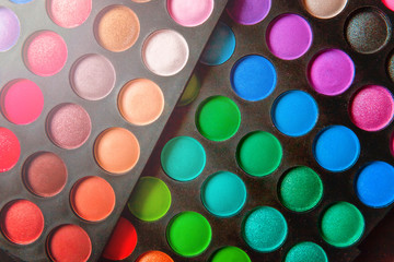 Tools for makeup and cosmetics different shades of eyeshadow palette and make up brush on trendy colorful blue pastel background. Top view flat lay and picturesque