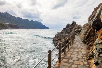 Poster de jardin Perspective view of a stone roa above ocean